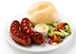 Grilled sausages, breadroll and vegetables