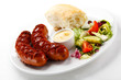 Grilled sausages, breadroll and vegetables