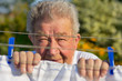 Senior hängt ein Bettlaken auf