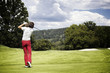 Photo: Woman teeing-off golf ball. Woman teeing-off golf ball.
