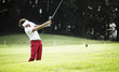 Woman pitching at golf course.