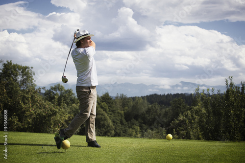Photo: Golfer teeing off. Golfer teeing off.
