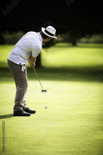 Photo: Male golfer putting Male golfer putting