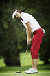 Photo: Female golfer putting Female golfer putting