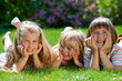 three cute girls outdoor in the grass smiling