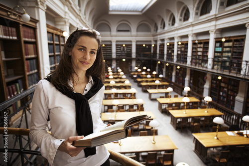 Foto: Friendly student reading in library upstairs. Friendly student reading in library upstairs.