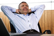 Foto: Smiling manager relaxing in office chair. Smiling manager relaxing in office chair.
