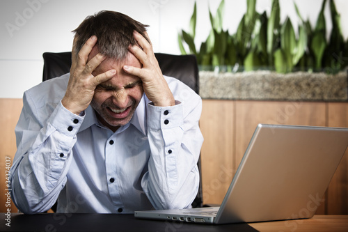 Photo: Angry business manager in front of office computer. Angry business manager in front of office computer.
