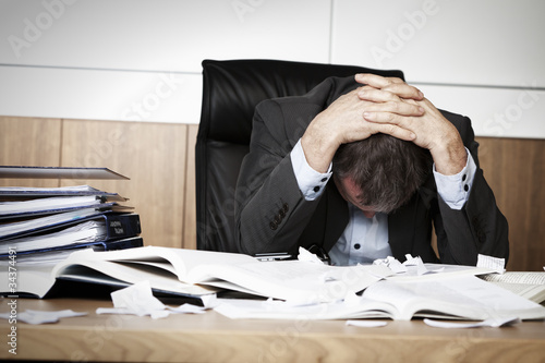 Photo: Frustrated business person overloaded with work. Frustrated business person overloaded with work.