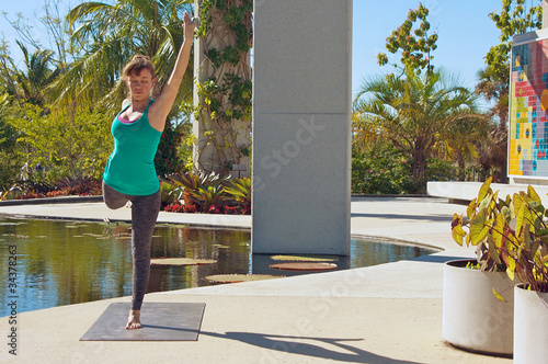 Photo: woman doing yoga outdoors in dancer variation pose front view woman doing yoga outdoors in dancer variation pose front view