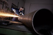 Foto: Worker cutting pipe with angel grinder. Worker cutting pipe with angel grinder.