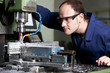 Laborer at milling machine.