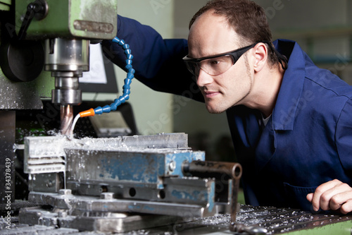 Foto: Laborer at milling machine. Laborer at milling machine.