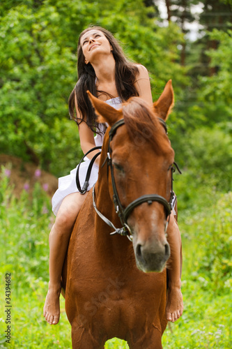Photo: young smiling woman riding horse young smiling woman riding horse