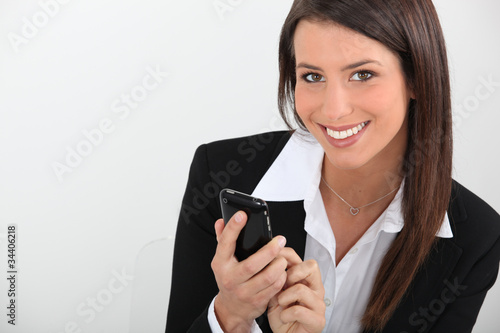 Foto: Smart young businesswoman using a smartphone Smart young businesswoman using a smartphone