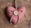 Heart with button on on wooden background Heart with button on on wooden background