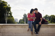 Photo: A young couple sitting on a wall, reading a guidebook A young couple sitting on a wall, reading a guidebook
