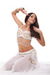 sensual woman belly dancer in white costume sitting on the floor