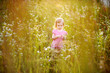 Adorable little girl in a meadow at summer or autumn