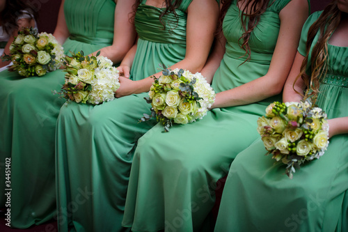 Photo: Row of bridesmaids with bouquets at wedding ceremony Row of bridesmaids with bouquets at wedding ceremony