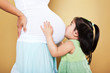 Photo: Girl kissing pregnant mother Girl kissing pregnant mother