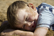 Happy boy lying on beach