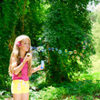 Children blowing soap bubbles in outdoor forest