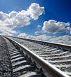low view to railroad under deep blue cloudy sky low view to railroad under deep blue cloudy sky