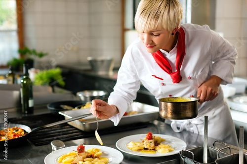 Photo: Female chef in a restaurant or hotel kitchen cooking Female chef in a restaurant or hotel kitchen cooking