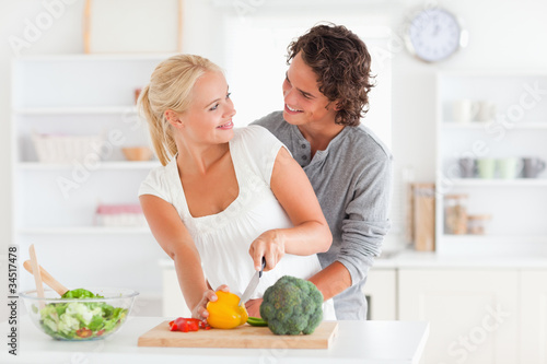 Foto: Happy couple slicing pepper Happy couple slicing pepper