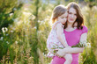 Young mother and her little girl in a meadow