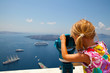 Girl looking with binoculars in Thira, Santorini, Greece