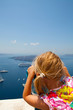 Girl looking with binoculars in Thira, Santorini, Greece