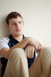 Teenager sits leaning back against wall