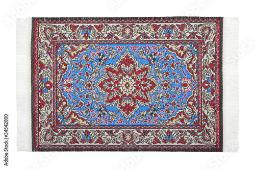 Photo: One oriental red-blue carpet horizontally lies on white One oriental red-blue carpet horizontally lies on white