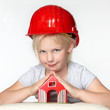 Foto: Little girl with building-site helmet protecting a wendy house Little girl with building-site helmet protecting a wendy house