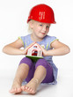 Foto: Cute girl with building-site helmet protecting a wendy house Cute girl with building-site helmet protecting a wendy house