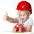 Little girl with helmet showing thump up for building a house