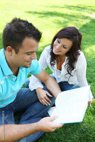 Photo: Couple Studying on Grass Couple Studying on Grass