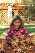 Young girl plays in a pile of leaves Young girl plays in a pile of leaves