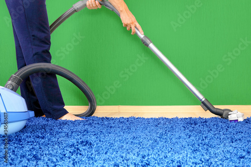 Photo: Vacuum cleaner in action-men cleaner a carpet. Vacuum cleaner in action-men cleaner a carpet.