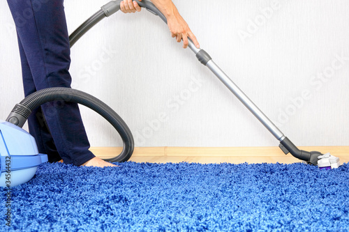 Photo: Vacuum cleaner in action-men cleaner a carpet. Vacuum cleaner in action-men cleaner a carpet.