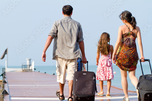 Photo: A young and attractive family with their luggages. A young and attractive family with their luggages.