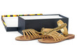 Pair of brown leather female sandals near opened box