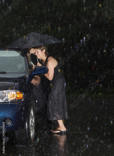 Photo: Woman locked out of her car in the rain Woman locked out of her car in the rain
