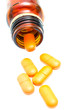 Pills spilling out of pill bottle isolated on white