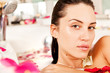 Attractive naked girl enjoys a bath with milk and rose petals