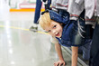 Photo : Boy playing hide and seek under the clothes rack at the shop Boy playing hide and seek under the clothes rack at the shop