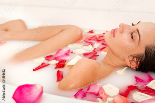 Photo: Attractive naked girl enjoys a bath with milk and rose petals Attractive naked girl enjoys a bath with milk and rose petals