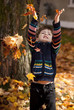 little boy playing in leaves
